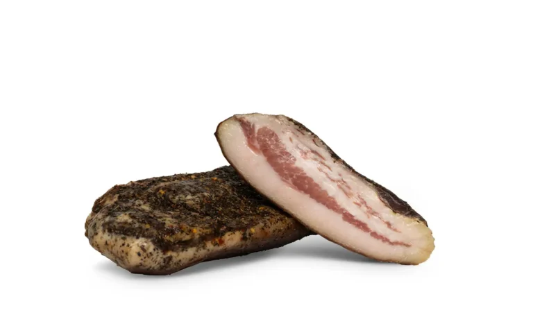 Guanciale van RAUWR, met een gekruide buitenkant en een aangesneden stuk met een dikke witte vetlaag en roze vlees